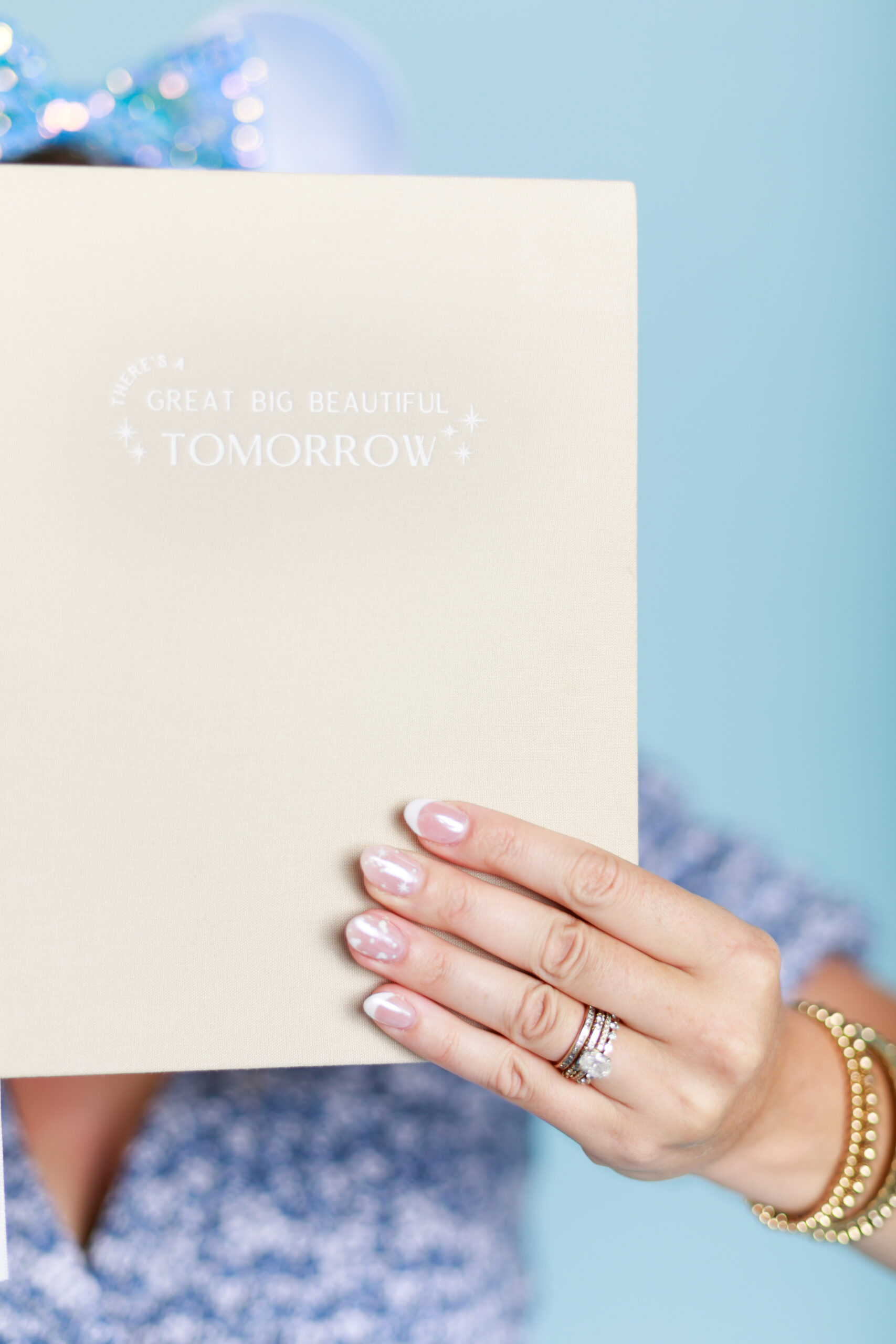 Disney travel planner holding up Disney planner with Mickey Mouse nails