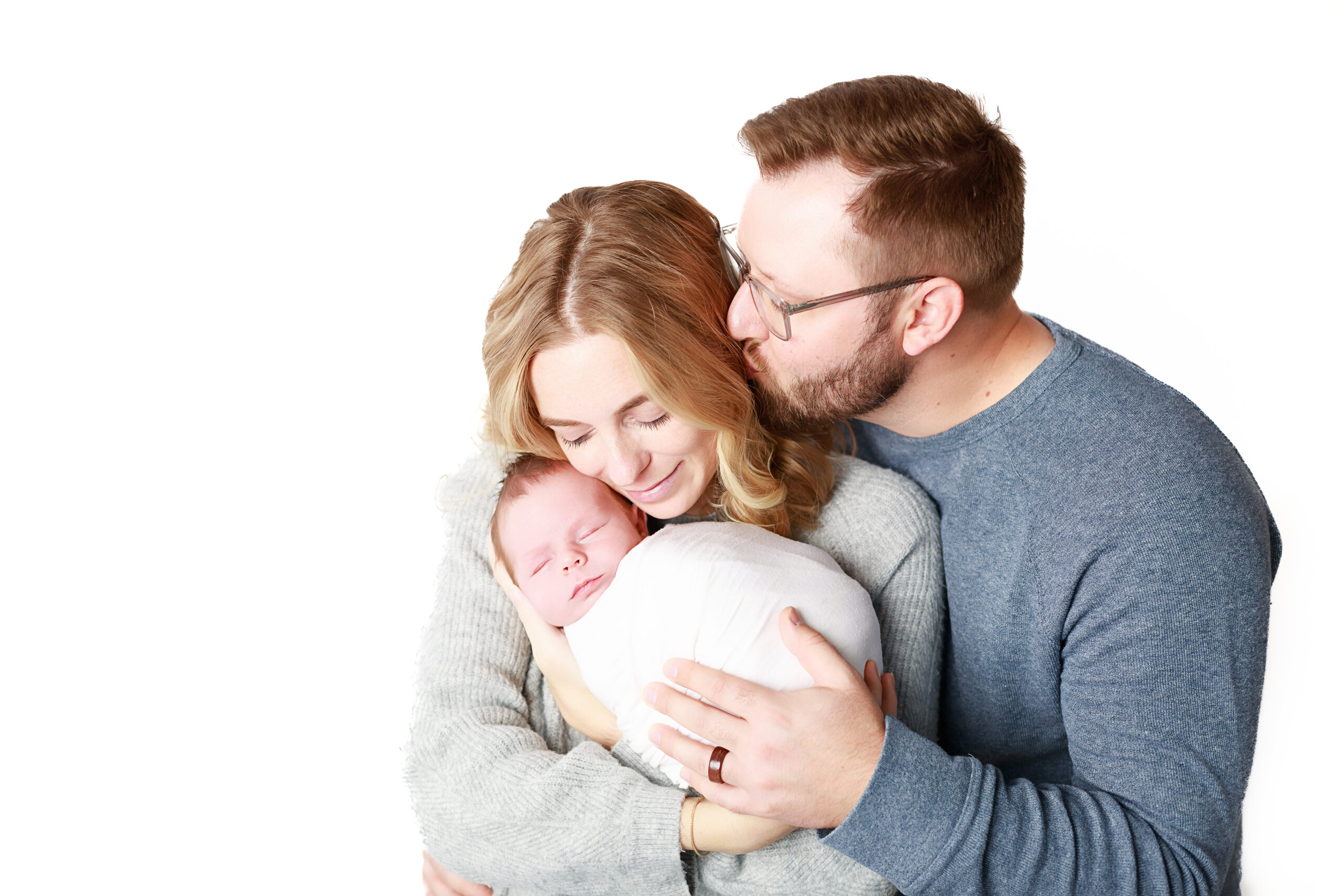 newborn and their parents snuggling at their photo session in Milwaukee Wisconsin